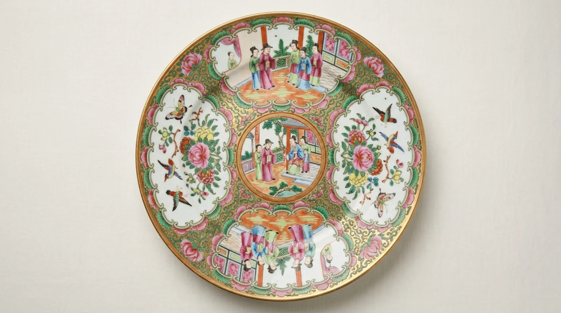 An antique Rose Medallion Canton porcelain plate with famille-rose reserves and a gilded rim